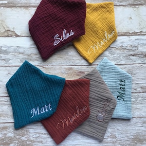 May include: Six personalized baby bibs in various colors and fabrics. The bibs are embroidered with the names Silas, Marlow, Matt, Marlow, Connie, and Matt.