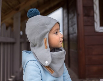 SET. Berretto invernale grigio per bambini con pompon e sciarpa.