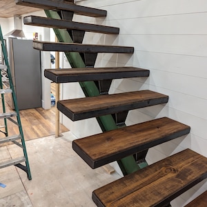 May include: A set of wooden stairs with metal supports. The stairs are stained a dark brown color and have a rustic look. The metal supports are painted a dark green color.