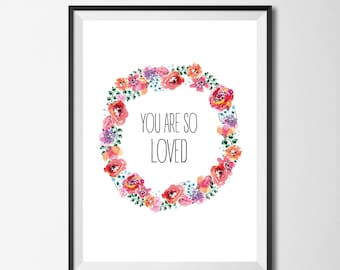 Könnte beinhalten: Ein weißer druckbarer Kunstdruck mit einem Aquarell-Blumenkranz in Rosa-, Orange- und Lilatönen. Der Kranz umgibt den Text "You are so loved".