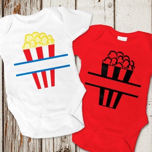 Könnte beinhalten: Zwei weiße und rote Baby-Bodys mit einem Popcorn-Eimer-Design und einem leeren Platz für einen Namen. Die Bodys befinden sich auf einem weißen Holz-Hintergrund.