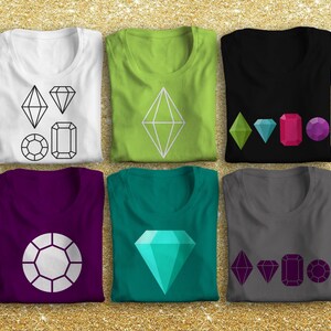 May include: Six folded t-shirts with different geometric diamond designs printed on them. The shirts are in various colors, including white, green, black, purple, teal, and gray.