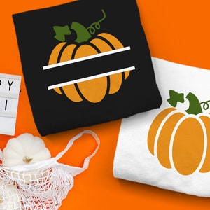May include: Two t-shirts with pumpkin designs, one black and one white, are displayed on an orange background. The black shirt has a pumpkin graphic with a horizontal white bar. The white shirt has a pumpkin graphic. A sign reads "HAPPY FALLI DAYS".
