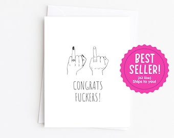 May include: A white greeting card featuring a black line drawing of two hands, each with a finger raised, and one hand wearing a ring. Below the illustration, the text reads CONGRATS FUCKERS! in a simple, clean, black sans-serif font.