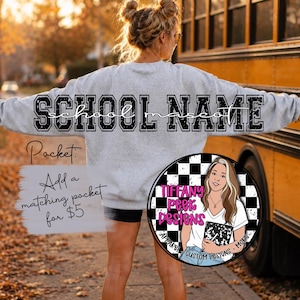 May include: A light gray crewneck sweatshirt featuring the text SCHOOL NAME in large black block letters with a distressed finish, and the word school mascot in a cursive script font centered below the primary text on the back of the garment.