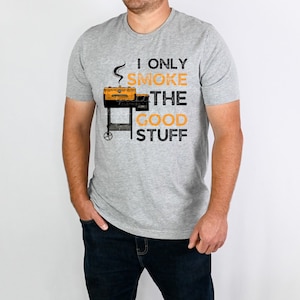 May include: A gray t-shirt with the text "I only smoke the good stuff" and a cartoon image of a grill.
