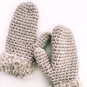 May include: A pair of beige crocheted mittens with a faux fur trim.