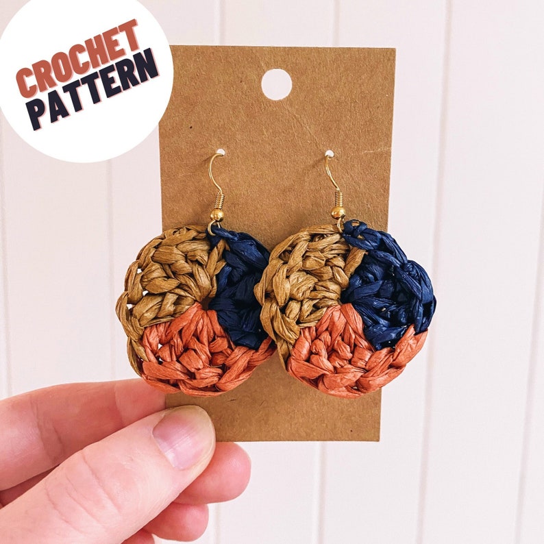 May include: Crochet earrings with a gold hook and a circular design in shades of brown, orange, and blue.