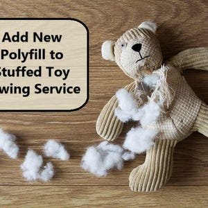 May include: A beige corduroy teddy bear with a torn chest area exposing white polyfill stuffing, accompanied by loose tufts of white stuffing. A rectangular sign with rounded corners displays the text: Add New Polyfill to Stuffed Toy Sewing Service.