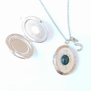 Può includere: Collana con ciondolo in argento, decorata con una pietra verde e un ciondolo a forma di lettera 'S'.