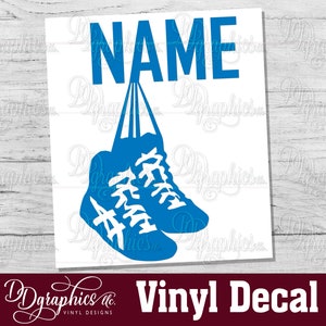 Op de afbeelding: Een blauwe vinyl sticker met het woord "NAME" en twee blauwe sneakers die aan de letters hangen. De sneakers hebben witte veters en witte details.