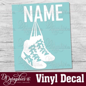 Op de afbeelding: Witte vinyl sticker van een paar sneakers die aan het woord "NAME" hangen op een lichtblauwe achtergrond.