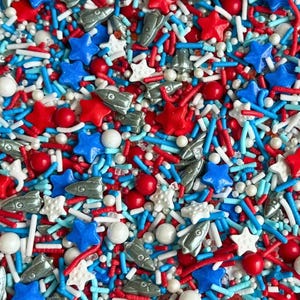 Macro close up of a buttercream frosting swirl decorated with metallic silver rocket ship sprinkles and red and blue stars. Luxury Birthday Sprinkles Custom Sprinkles Cake Sprinkles Cupcake Décor Rocket Birthday Décor Space Sprinkles