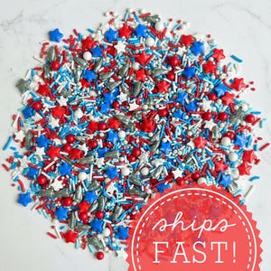 A large pile of red white and blue outer space sprinkles on a white marble surface with a red sticker saying Ships Fast. Luxury Birthday Sprinkles Custom Sprinkles Cake Sprinkles Cupcake Décor Rocket Birthday Décor Space Sprinkles