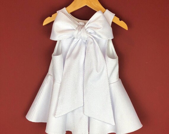The "Bow-Backed Peplum" in White Pique.