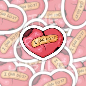 May include: A heart-shaped sticker featuring a red heart with a dark brown stitched patch on the upper left side and a tan adhesive bandage across the center. The bandage has the text I CAN DO IT printed in black capital letters.
