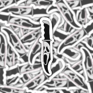 May include: A black and white sticker of a knife with a ghost face mask on the blade. The text on the blade reads "www.etsy.com/shop/THEGHOSTYGOBLINS".