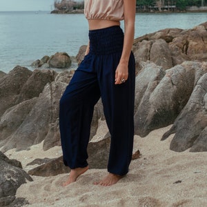 plain navy blue loose yoga trousers with 1 side pocket, a smock waistband and elasticated ankles