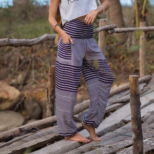 purple and white horizontal striped loose trousers with elasticated, tapered ankles and smock waistband