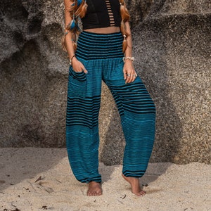 bright blue and black horizontal pinstripe high crotch harem pants with a pocket on the right side near the hip. made from rayon they're loose fitting and comfortable.