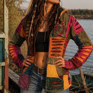 Könnte beinhalten: Eine langärmelige Kapuzenjacke mit Reißverschluss und Patchwork-Design in Olivgrün, Senfgelb, Magenta und Violett. Das Kleidungsstück weist horizontale Ausschnittdetails an Brust, Ärmeln und Taschen auf, die eine kontrastierende Stoffschicht zeigen.