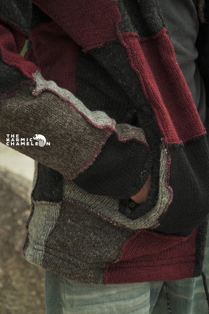 May include: A patchwork knit jacket in shades of gray, black, and burgundy. The jacket features a variety of textured knit panels, with visible seams and a zipper. The Karmic Chameleon logo is visible on the left side.