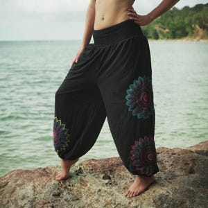May include: Black harem pants with a gathered waistband and floral embroidery in shades of teal, red, and yellow. The loose-fitting pants are made of a lightweight fabric and are suitable for casual wear.