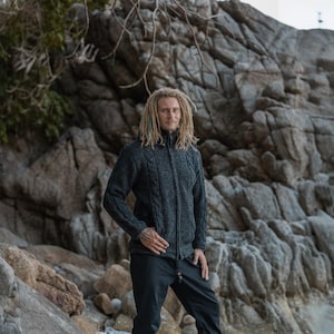 Model wearing a grey cable knit hoodie which zips up the middle - ideal for those who love timeless fashion, outdoor lovers and ethical fashion followers