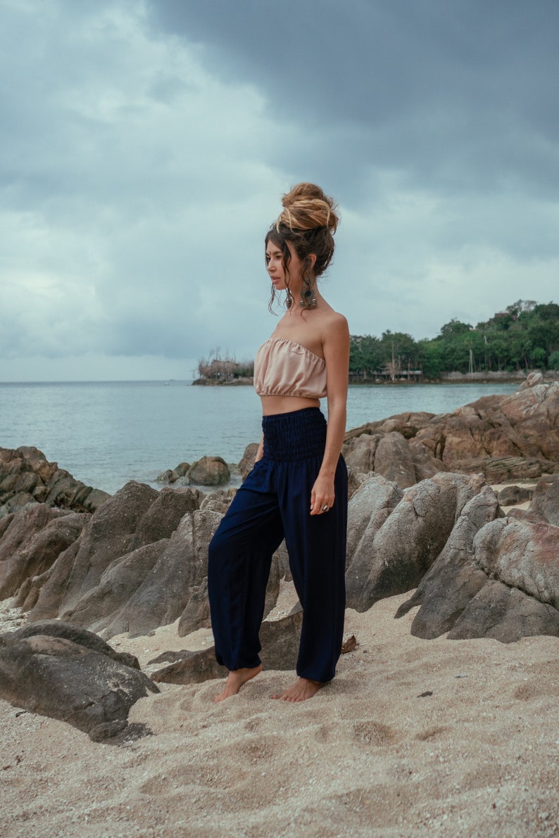 plain navy blue loose yoga trousers with 1 side pocket, a smock waistband and elasticated ankles