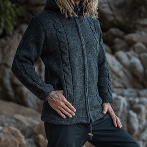 Close-up showing front pockets and cable knit wool design of this charcoal grey wool hoodie - ideal for winter woodland and mountain walks