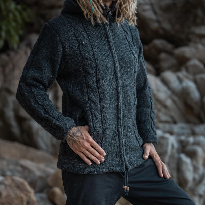 Close-up showing front pockets and cable knit wool design of this charcoal grey wool hoodie - ideal for winter woodland and mountain walks