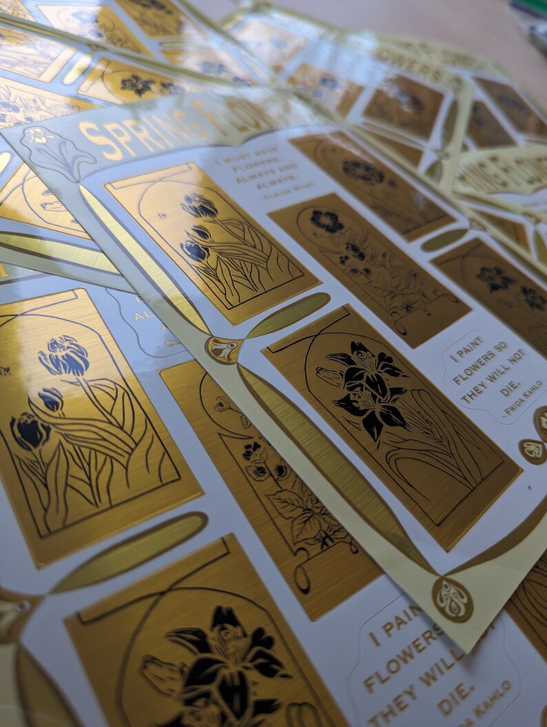 May include: Gold foil stickers with black line drawings of flowers and the quote "I paint flowers so they will not die." by Frida Kahlo.