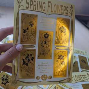 May include: A set of gold foil stickers featuring different spring flowers and quotes about flowers. The stickers are on a white background and have a gold border. The quotes include "I must have flowers, always and always." - Claude Monet and "I paint flowers so they will not die." - Frida Kahlo.