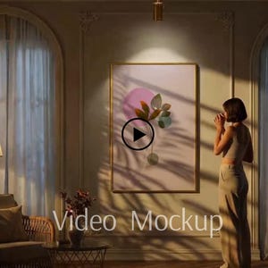 Puede incluir: Una obra de arte enmarcada con un borde dorado presenta formas botánicas abstractas en rosa, verde y marrón sobre un fondo claro. Las palabras "Video Mockup" son visibles en la pared. La escena está iluminada por luz cálida.