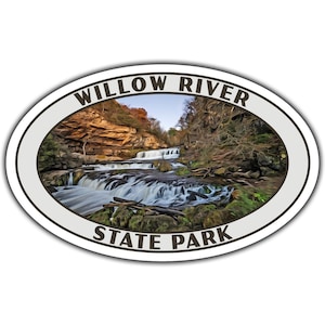 May include: Oval sticker featuring a scenic view of Willow River State Park. The image shows a cascading waterfall surrounded by lush greenery and rocky cliffs. The park's name is printed in a bold, white font.