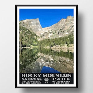 May include: A vintage-style poster featuring a scenic view of a lake reflecting the Rocky Mountains in Colorado. The poster is titled "Rocky Mountain National Park" and includes the text "U.S. Department of the Interior, National Park Service, Colorado Est. 1915."