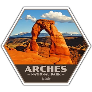 May include: A hexagonal sticker with a colorful illustration of Delicate Arch in Arches National Park, Utah. The text "ARCHES - NATIONAL PARK - Utah" is printed below the image.