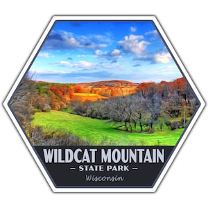 May include: A hexagonal sticker featuring a scenic landscape of Wildcat Mountain State Park in Wisconsin. The image showcases a vibrant green field, colorful autumn trees, and a blue sky with fluffy clouds. The park's name and location are printed at the bottom.