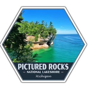 May include: A hexagonal sticker with a scenic image of a rocky cliff with trees and a blue lake. The text "PICTURED ROCKS - NATIONAL LAKESHORE - Michigan" is printed on the sticker.