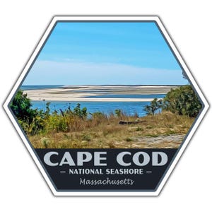 May include: A hexagonal sticker with a blue, white, and green landscape image. The text "CAPE COD - NATIONAL SEASHORE - Massachusetts" is printed on the sticker.