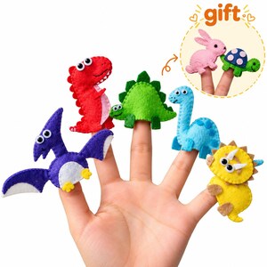May include: A set of colorful felt finger puppets featuring a red T-Rex, a purple pterodactyl, a green stegosaurus, a blue long-necked dinosaur, and a yellow triceratops. An inset circle shows a pink rabbit and a green turtle labeled as a gift.