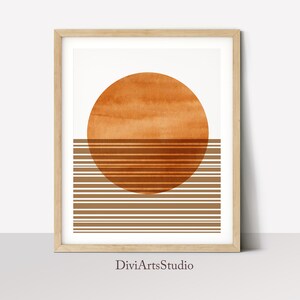 Pu&ograve; includere: Stampa d'arte astratta con un grande cerchio arancione e strisce orizzontali marroni. La stampa &egrave; incorniciata in una cornice di legno chiaro e ha il testo "DiviArtsStudio" in basso.