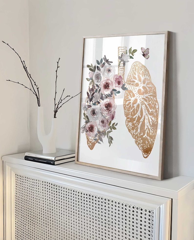 K&ouml;nnte beinhalten: Ein gerahmter Druck einer goldenen anatomischen Illustration von Lungen mit Aquarell-Rosen und wei&szlig;en Blumen und Gr&uuml;n.