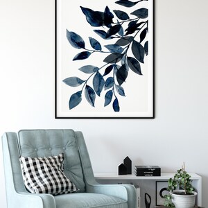 May include: A black and white framed print of a watercolor painting of a branch with blue leaves.
