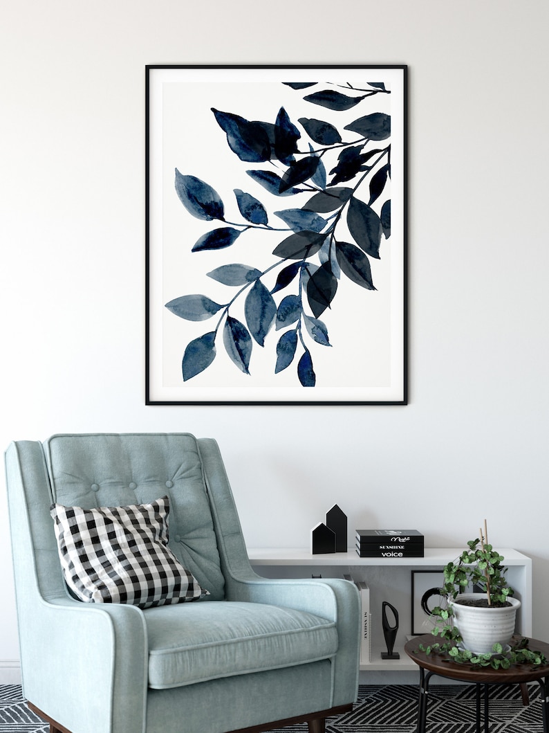 May include: A black and white framed print of a watercolor painting of a branch with blue leaves.