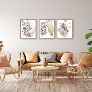 K&ouml;nnte beinhalten: Drei gerahmte Drucke mit anatomischen Illustrationen von Gehirn, Herz und Lunge, jeweils mit Aquarell-Blumenmotiven in Rosa-, Wei&szlig;- und Goldt&ouml;nen.