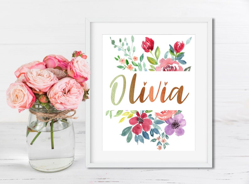 Pu&ograve; includere: Una stampa incorniciata bianca con un design floreale ad acquerello e il nome "Olivia" in lettere dorate.