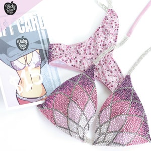 May include: Two pink and purple sequined bikini tops with a floral design. The tops are made of a sparkly fabric and have a variety of rhinestones.