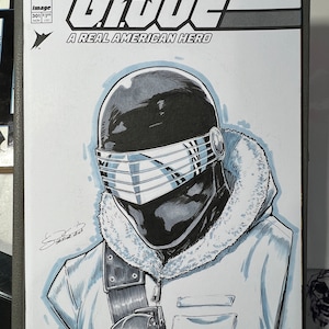 May include: A black and white illustration of a G.I. Joe character wearing a black helmet with a silver visor and a white fur-lined jacket. The image is from a comic book cover and includes the text "G.I. JOE A REAL AMERICAN HERO".