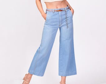 May include: Light blue wide-leg cropped jeans with a brown belt and a silver chain detail.